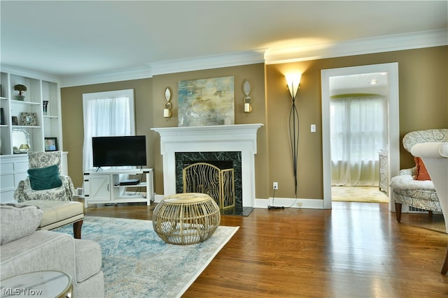 living room featuring a healthy amount of sunlight, hardwood / wood-style floors, and a high end fireplace