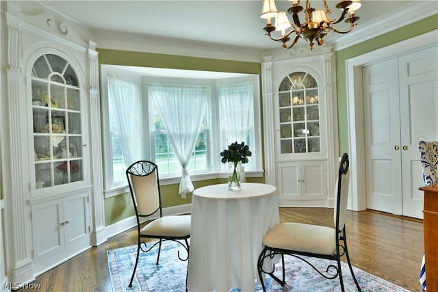 dining space with an inviting chandelier, hardwood / wood-style flooring, and ornamental molding