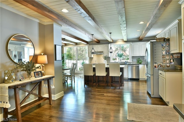 kitchen featuring beamed ceiling, tasteful backsplash, dark hardwood / wood-style floors, and stainless steel appliances