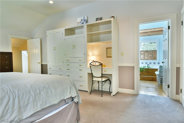 bedroom with lofted ceiling and light carpet