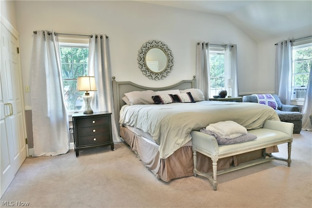 bedroom featuring light carpet and vaulted ceiling