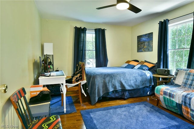 bedroom with multiple windows, hardwood / wood-style floors, and ceiling fan