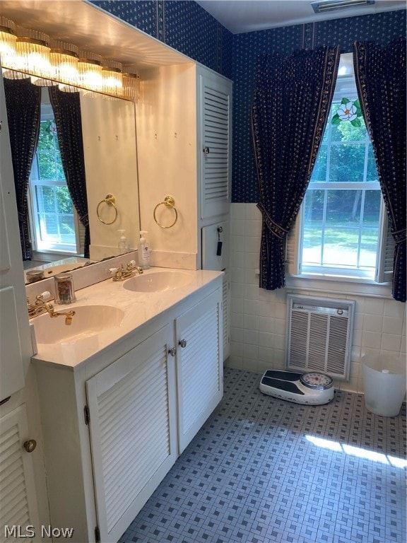 bathroom with vanity, tile walls, and plenty of natural light