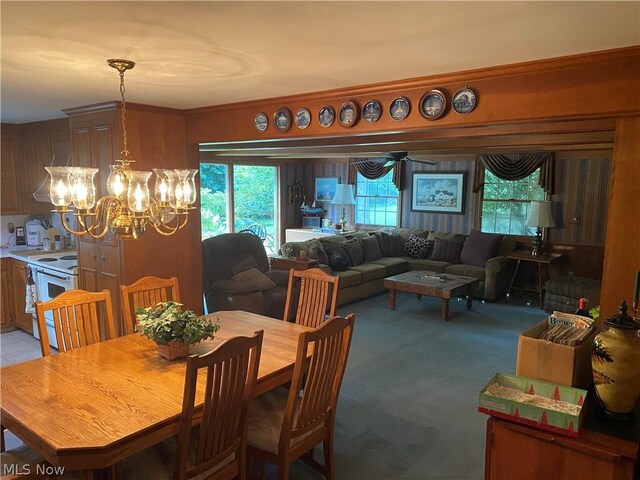 carpeted dining area featuring a notable chandelier