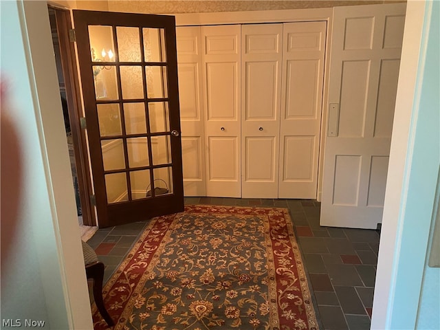 doorway to outside with dark tile patterned flooring