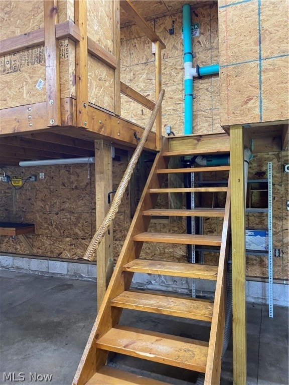 staircase featuring concrete flooring