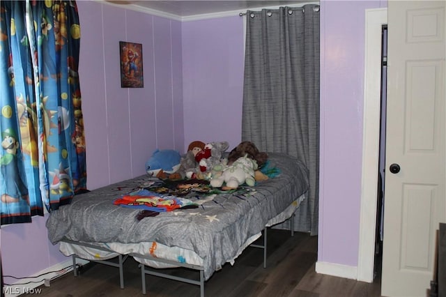 bedroom featuring crown molding and dark hardwood / wood-style floors