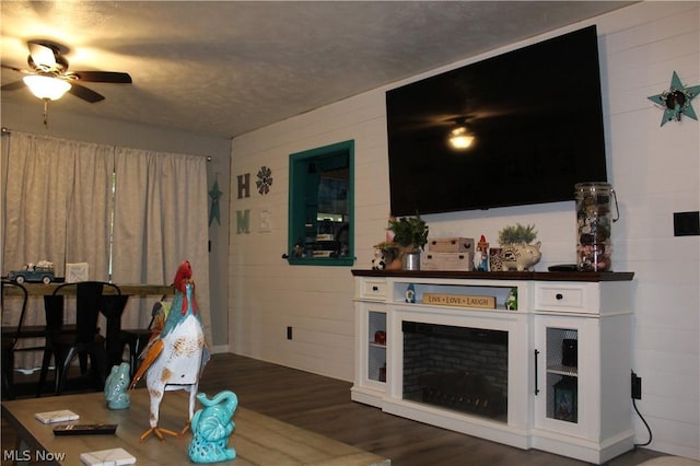 living room with dark wood-type flooring and ceiling fan