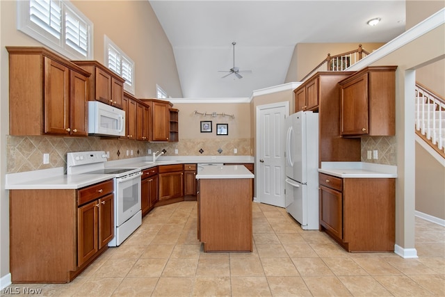 kitchen with tasteful backsplash, white appliances, a center island, ceiling fan, and high vaulted ceiling