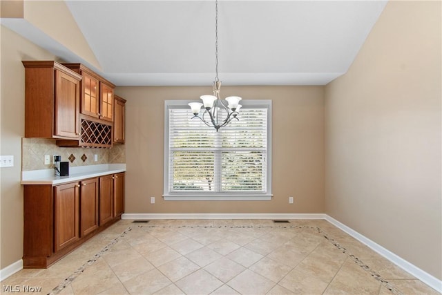 unfurnished dining area with lofted ceiling, light tile patterned floors, and a chandelier