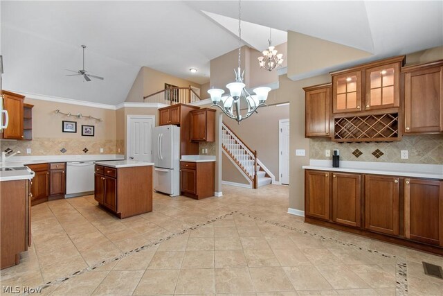 kitchen with light tile patterned flooring, a kitchen island, tasteful backsplash, and white appliances