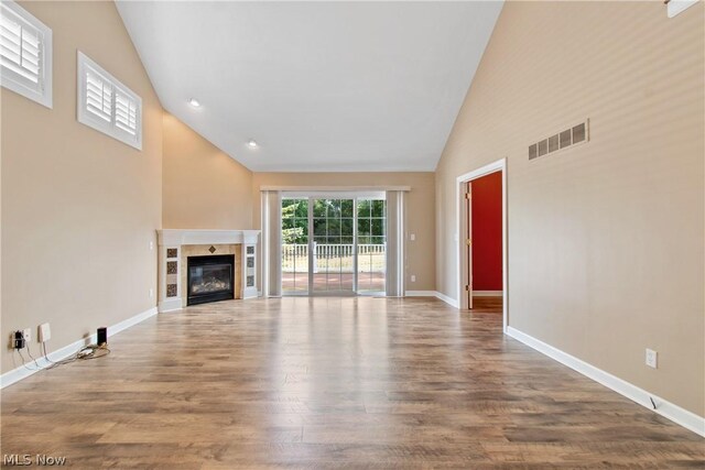 unfurnished living room with hardwood / wood-style flooring and high vaulted ceiling