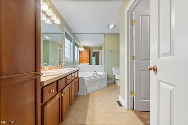 bathroom with a tub to relax in, toilet, tile patterned flooring, and vanity