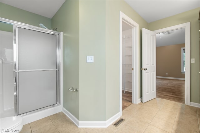 bathroom with tile patterned floors and an enclosed shower