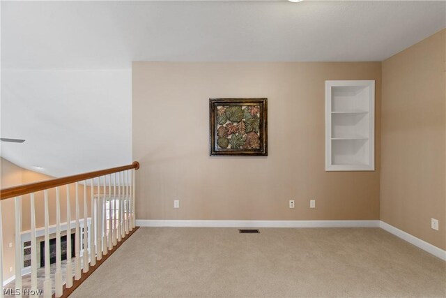 empty room with built in features and carpet flooring