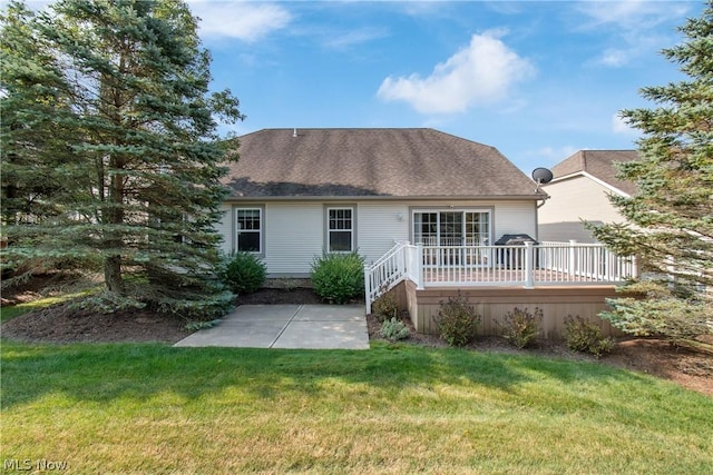 rear view of house with a wooden deck and a yard