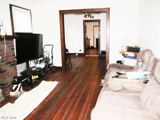 living room with ceiling fan and dark hardwood / wood-style flooring