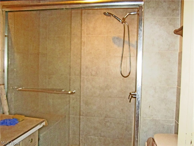 bathroom featuring vanity, an enclosed shower, and toilet