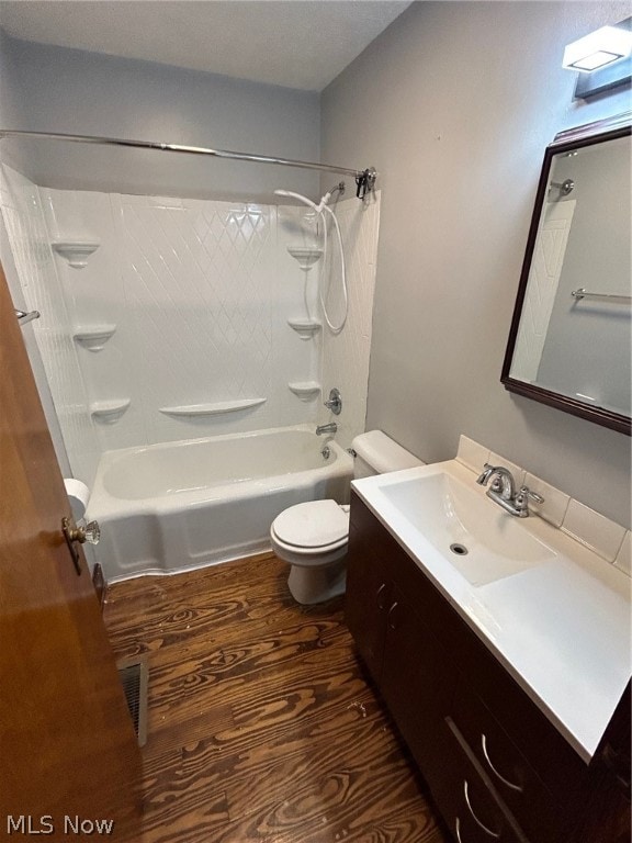 full bathroom featuring vanity, hardwood / wood-style flooring, tub / shower combination, and toilet