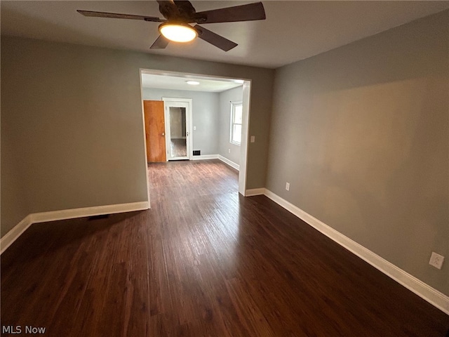 empty room with dark hardwood / wood-style floors and ceiling fan