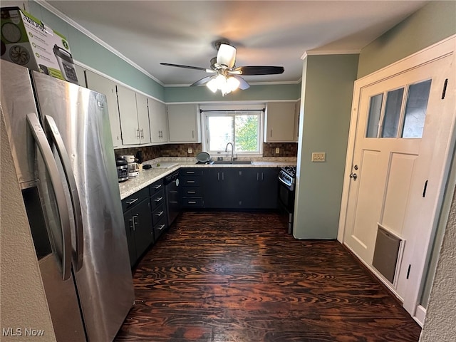 kitchen featuring dark wood-type flooring, gas stove, sink, tasteful backsplash, and stainless steel fridge