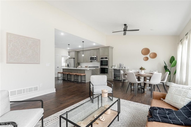 living room featuring ceiling fan, sink, and dark hardwood / wood-style flooring