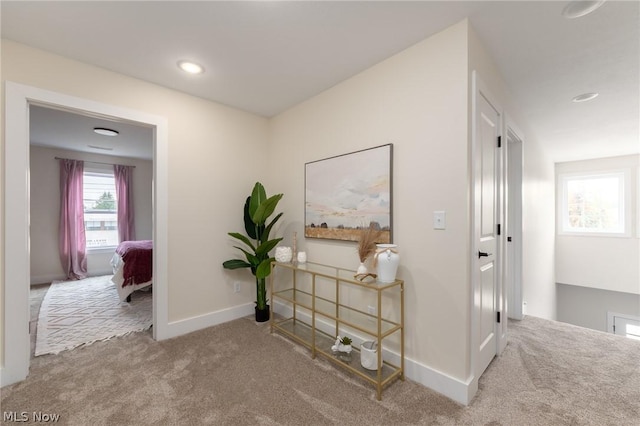 hallway featuring light colored carpet