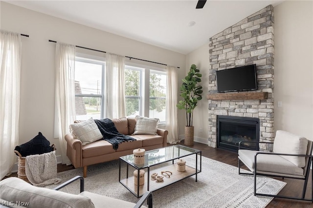 living room featuring wood-type flooring, lofted ceiling, and a fireplace