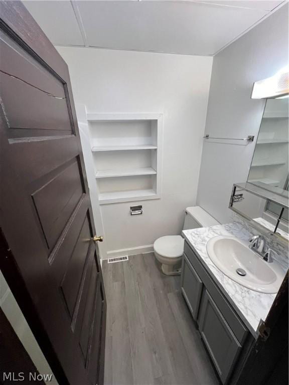 bathroom with vanity, hardwood / wood-style floors, and toilet