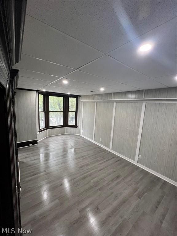 spare room featuring wood-type flooring and wooden walls