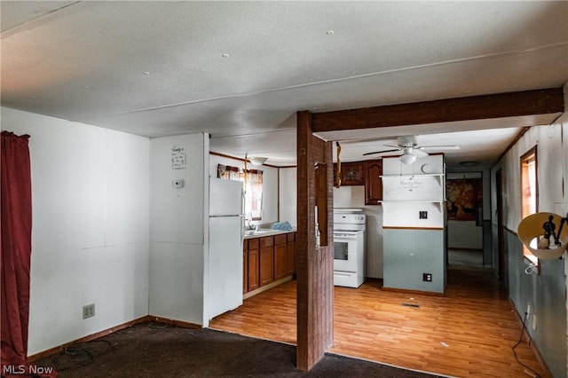 kitchen with sink, white appliances, ceiling fan, light hardwood / wood-style floors, and beam ceiling