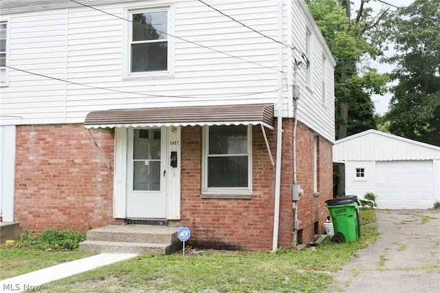 view of front of home featuring a garage and an outbuilding