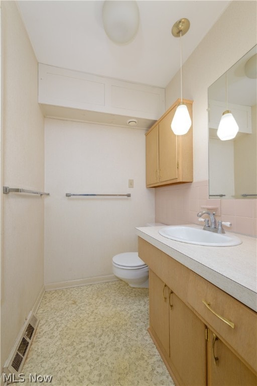 bathroom featuring vanity, decorative backsplash, toilet, and tile patterned floors