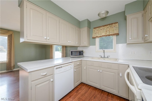 kitchen featuring sink, hardwood / wood-style floors, white dishwasher, white cabinets, and kitchen peninsula