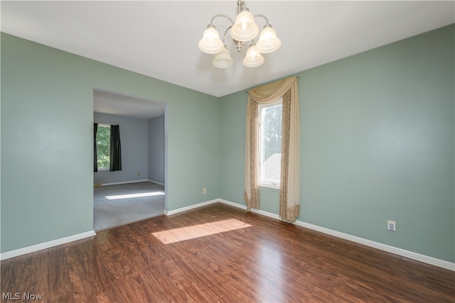 unfurnished room featuring hardwood / wood-style floors and an inviting chandelier