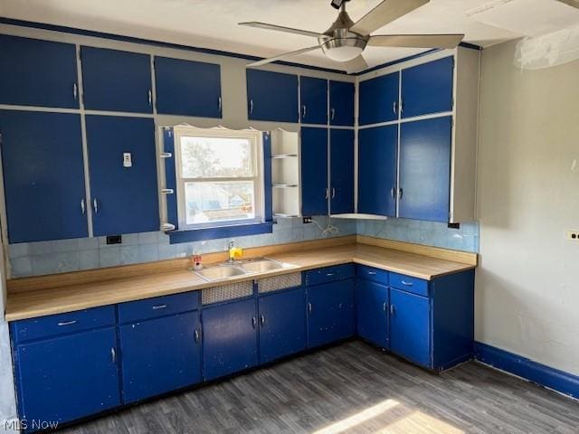 kitchen with blue cabinets, dark hardwood / wood-style flooring, and sink