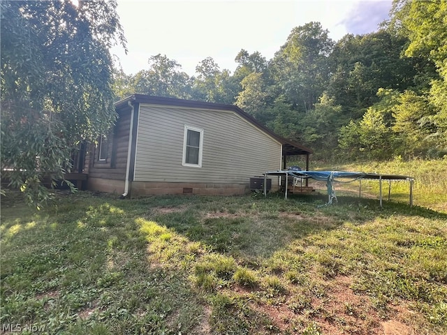 view of property exterior featuring a yard and a trampoline