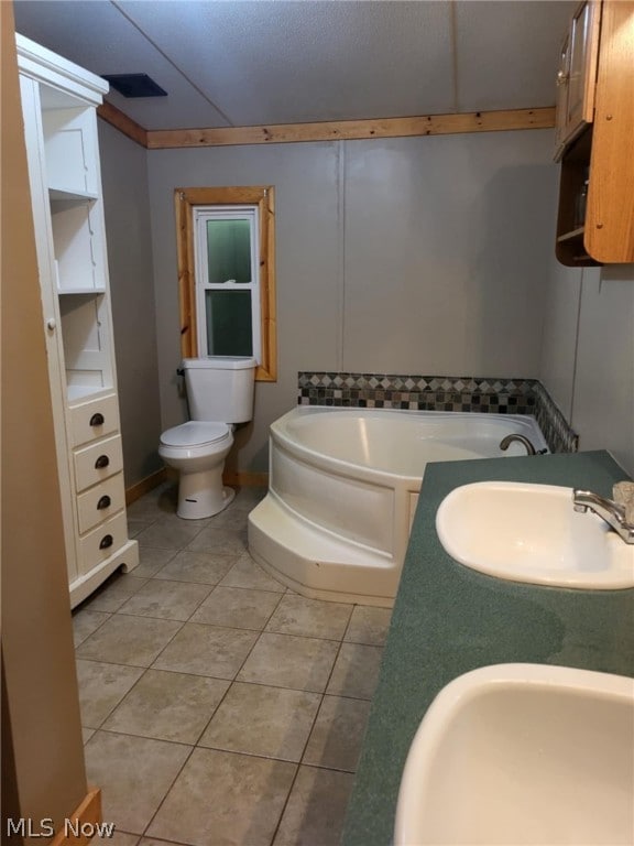 bathroom featuring toilet, tile patterned flooring, sink, and a bathtub