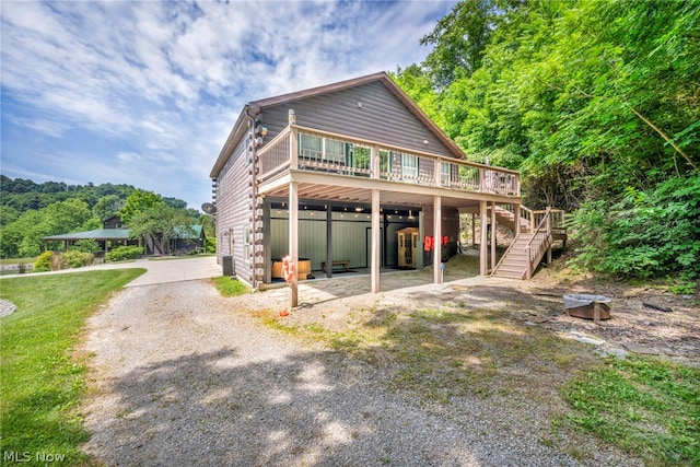 rear view of house featuring a garage and a deck