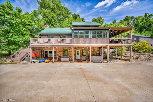 view of front of home featuring a wooden deck, a patio area, and central AC unit