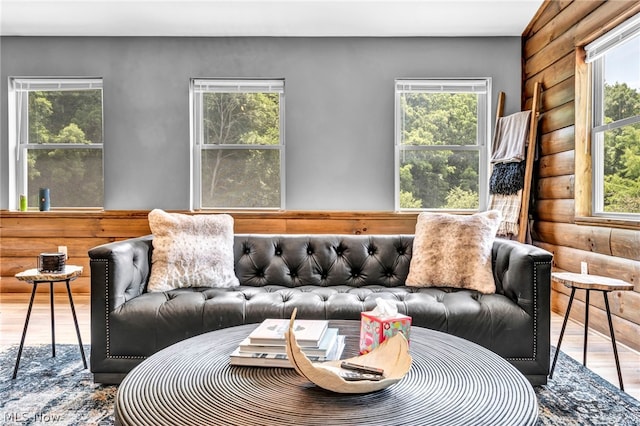 living room featuring hardwood / wood-style flooring, a healthy amount of sunlight, and log walls