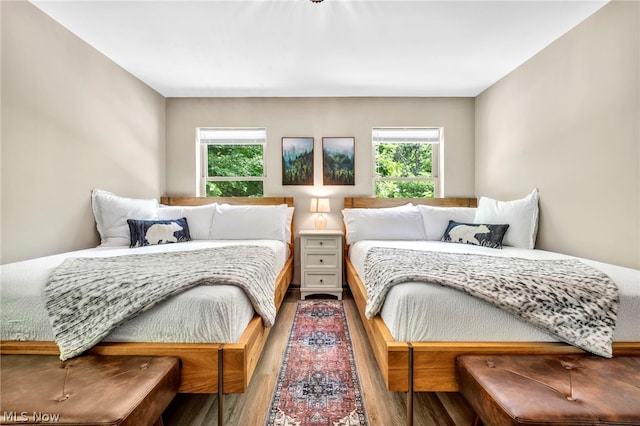 bedroom featuring wood-type flooring and multiple windows