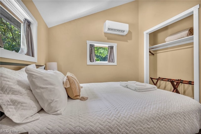 bedroom with lofted ceiling, multiple windows, a closet, and a wall mounted AC