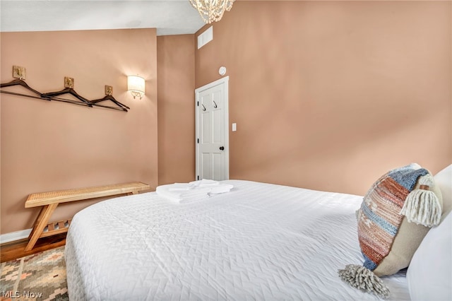 bedroom with hardwood / wood-style flooring and a towering ceiling