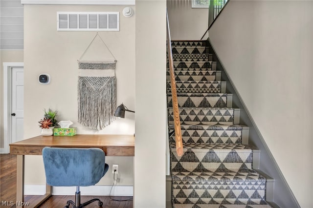 stairway with dark hardwood / wood-style flooring