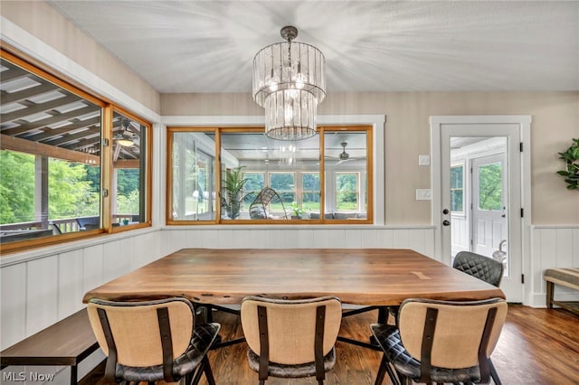 dining space with hardwood / wood-style floors and a chandelier