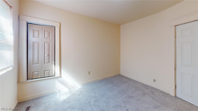 unfurnished room featuring light carpet