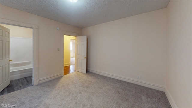 unfurnished bedroom featuring light carpet and a textured ceiling