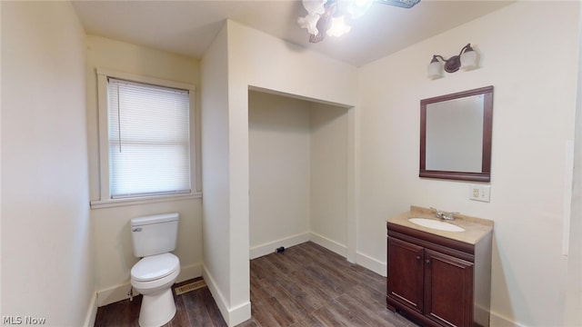 bathroom featuring wood-type flooring, toilet, and vanity