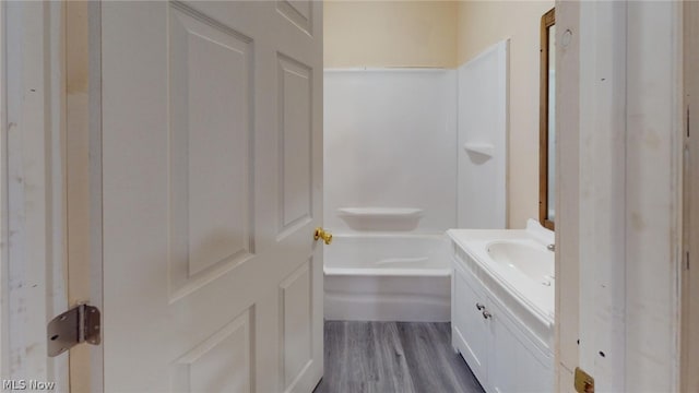 bathroom with a washtub, hardwood / wood-style floors, and vanity